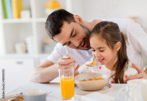 happy family eating flakes for breakfast at home