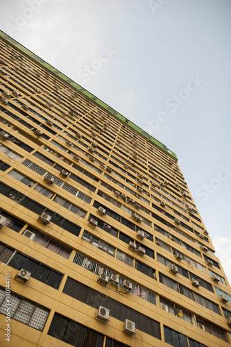 An low angle close-up view of a yellow tall building.