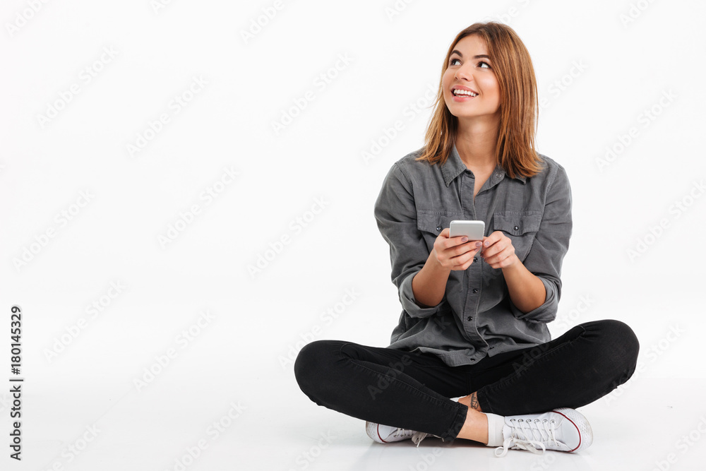 Portrait of a smiling pretty girl holding mobile phone