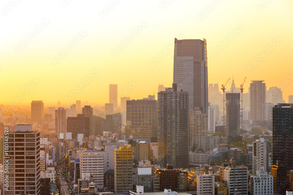 Cityscapes of Tokyo sunset, city aerial skyscraper view of office building and downtown and street of minato in tokyo with yellow sunlight background. Japan, Asia