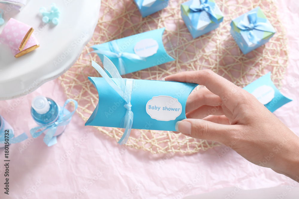 Woman holding box with baby shower favors Woman holding box with baby shower favors