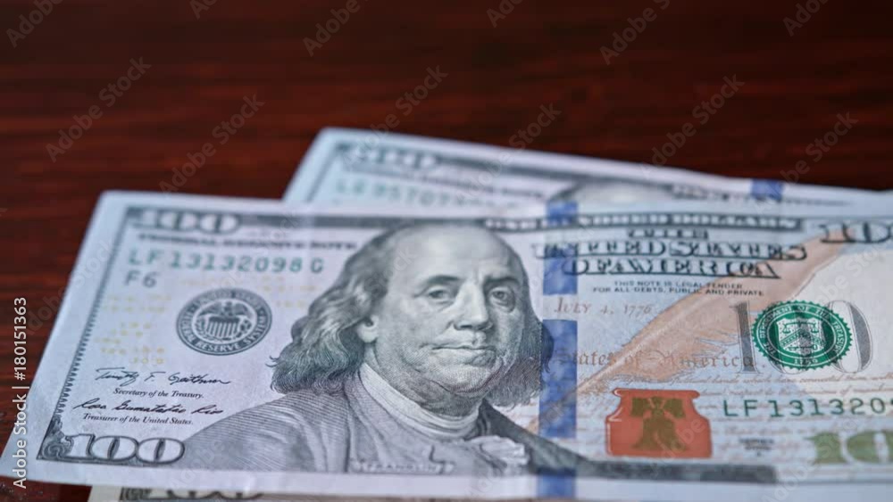 Fanned pile of hundred dollar banknotes on a table. Close-up shot Fanned pile of hundred dollar banknotes on a table. Close-up shot