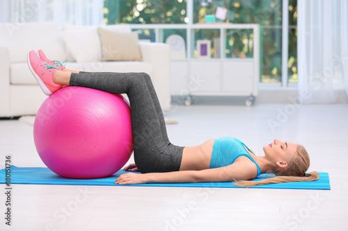 Young woman in sportswear doing exercises indoors