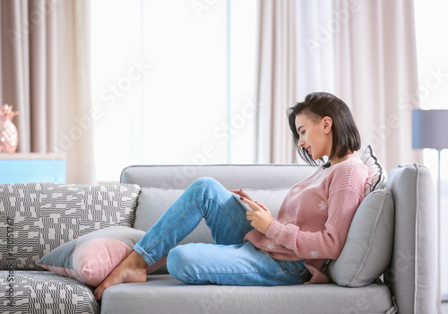 Young woman using tablet at home