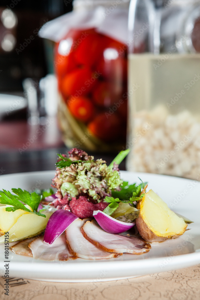 appetizer of meat, vegetables and potatoes on the table in the restaurant. appetizer of meat, vegetables and potatoes on the table in the restaurant.