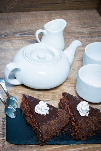 a teapot and a couple of cups with a cake on the table