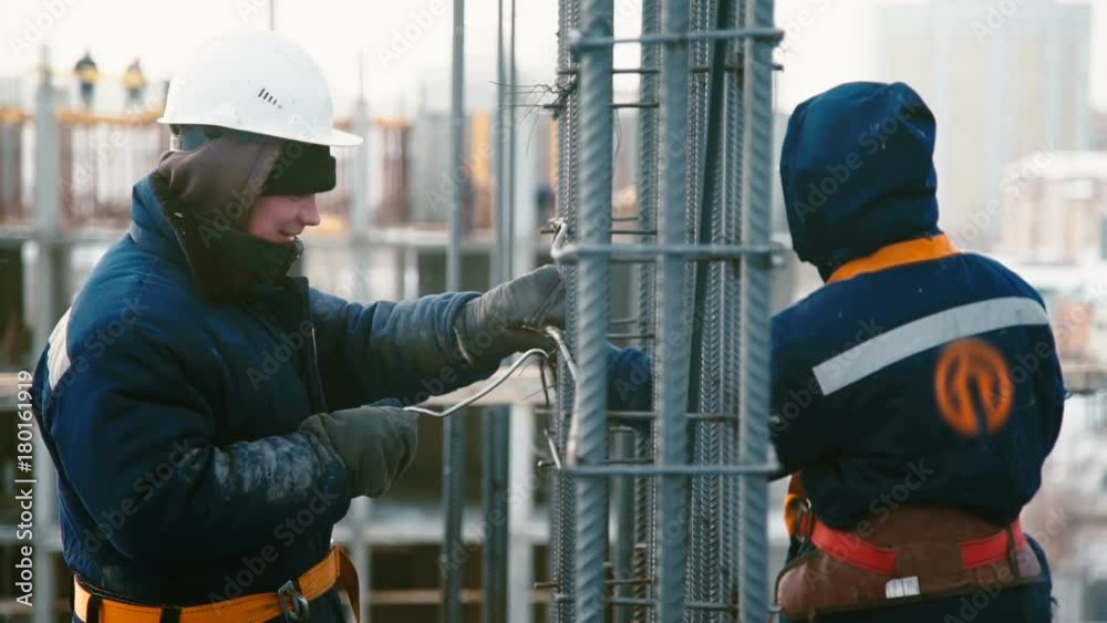 Workers at the construction site weaves the armature on the roof