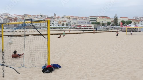 Kids playing soccer on the beach on a cloudy day