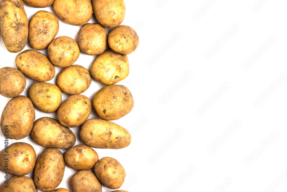 A lot of dirty potatoes on a white background. Potatoes scattered on the left side. A lot of dirty potatoes on a white background. Potatoes scattered on the left side.