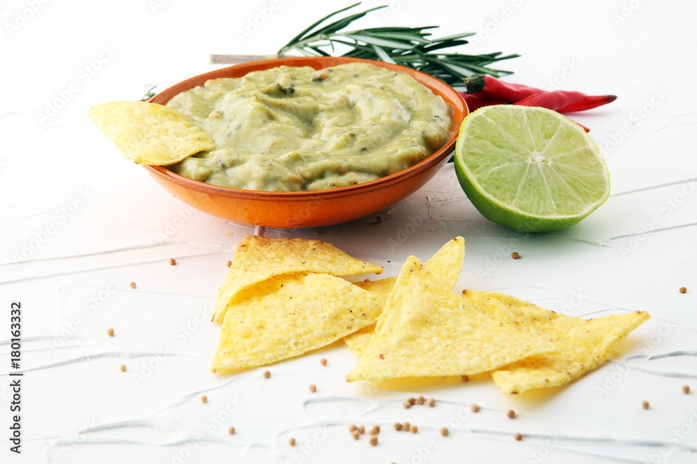 Bowl of guacamole with tortilla chips on white background