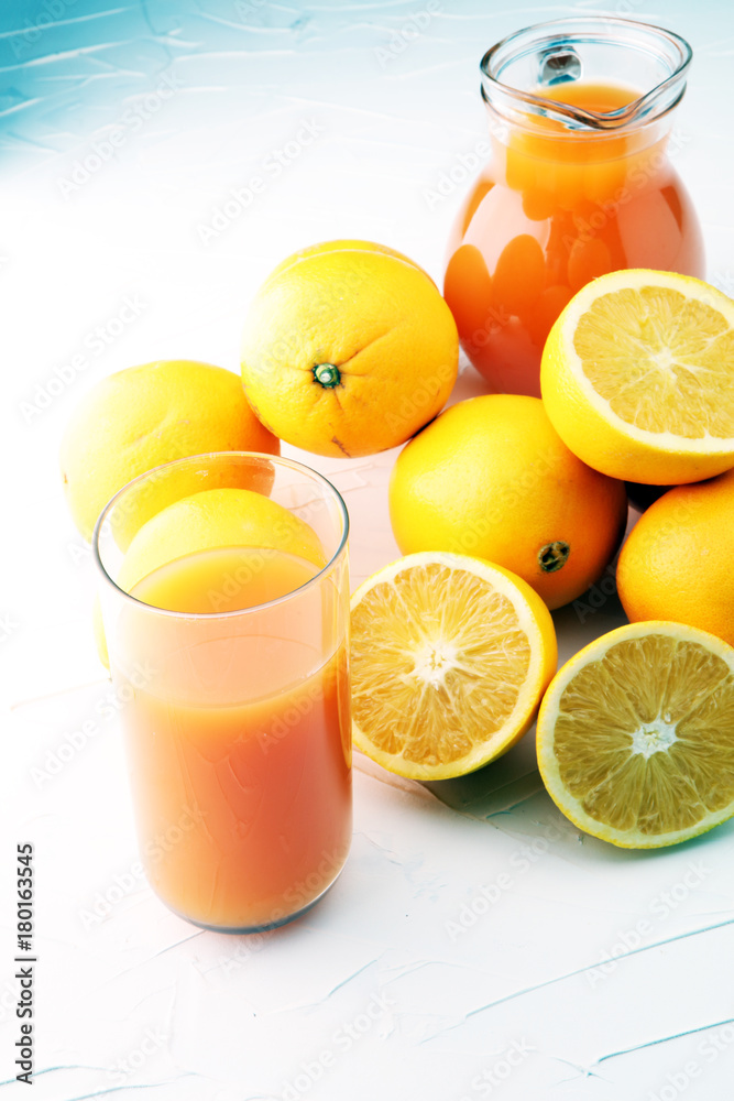 glass jar of fresh orange juice with fresh fruits on white table