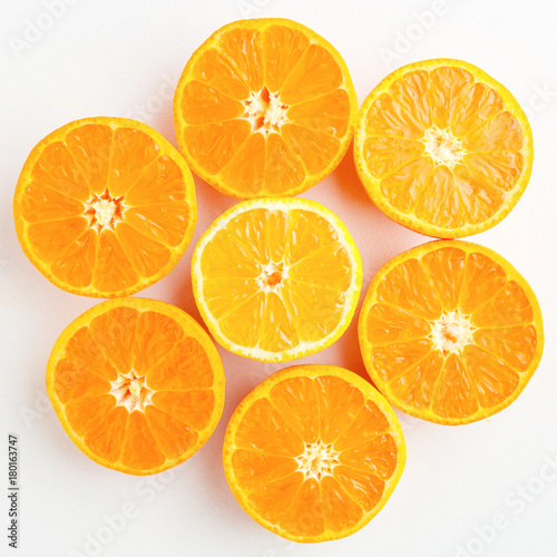 a pattern of orange and yellow mandarins cut in half on a white 