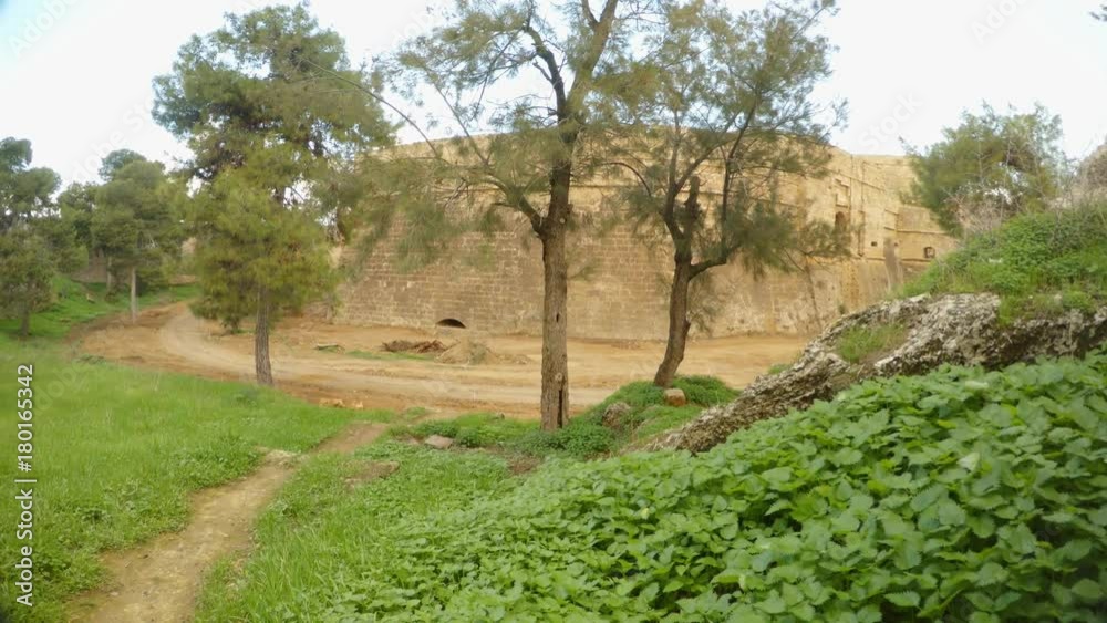 trees and grass grown in the deep moat of the ancient fortress of Famagusta with high walls trees and grass grown in the deep moat of the ancient fortress of Famagusta with high walls
