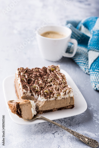 Portion of semifreddo cake, delicious chocolate dessert on white plate with cup of coffee on light gray background with copy space. photo