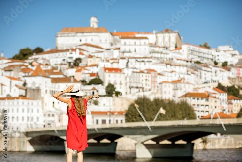 Young woman tourist in red dress enjoying great view on Coimbra city in the central Portugal