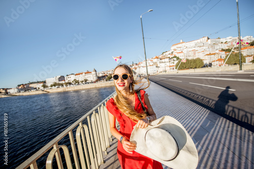 Woman walking on the bridge in Coimbra city during the sunset in the central Portugal