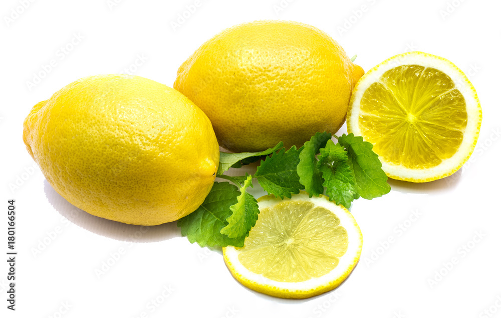 Two whole yellow lemons, cross section, slice and fresh green lemon balm leaves isolated on white background.