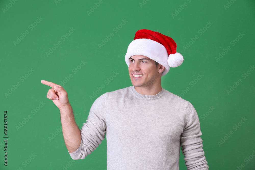 Handsome man in Christmas hat on color background Handsome man in Christmas hat on color background