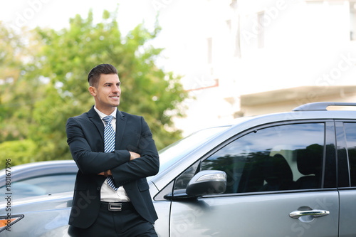 Attractive man in formal suit standing near car © Africa Studio