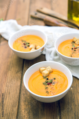Soup with sweet potatoes, carrots, pumpkin on wooden background