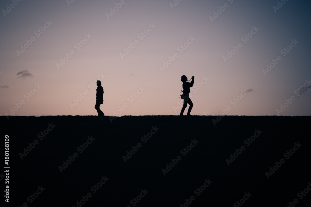 People silhouette on a top of a hill