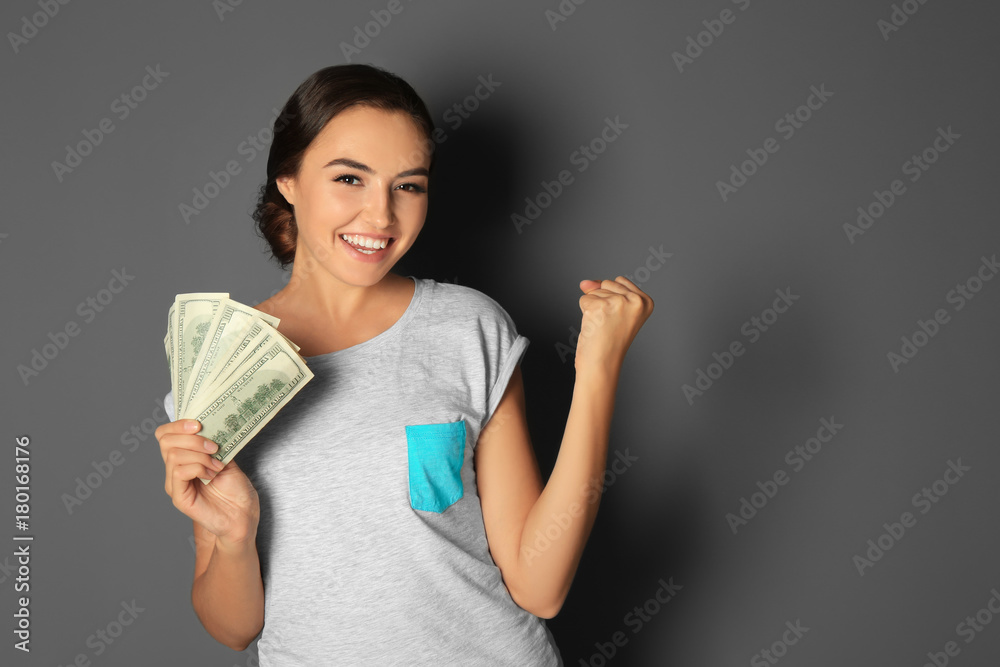 Young woman holding cash on grey background Young woman holding cash on grey background