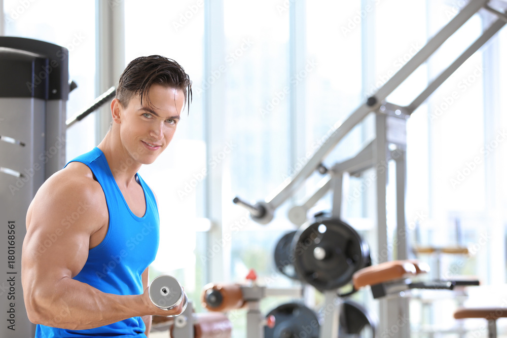 Muscular young man training in gym Muscular young man training in gym