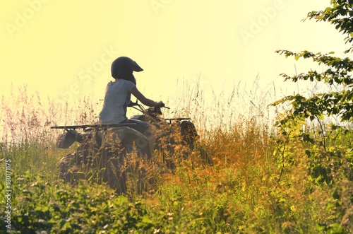 Young people driving a quad bike on a sunny day photo