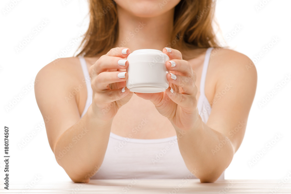 Beautiful woman sits a jar of hand cream Beautiful woman sits a jar of hand cream