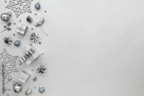 Monochrome Holiday pattern with gift boxes and New Year decoration, snowflakes on silver background. Total silver design, Christmas card, Minimal style. Flat lay