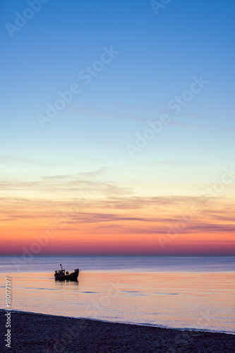 Small fisherman boat sailing at dusk