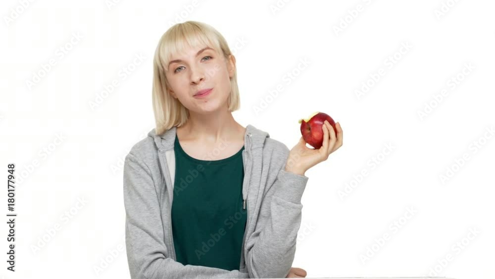 portrait in profile of happy woman 20s wearing casual clothes eating red juicy apple tasting enjoying fruit over white background copy space. Concept of emotions portrait in profile of happy woman 20s wearing casual clothes eating red juicy apple tasting enjoying fruit over white background copy space. Concept of emotions
