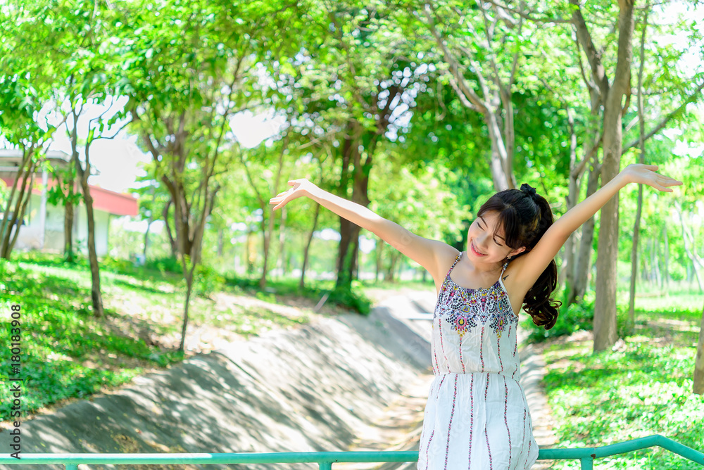 Naklejka premium A beautiful asian young girl on the bridge at forest with smile