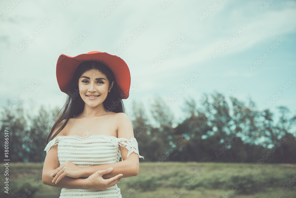 Portrait of happy asian woman wear red hat at the field
