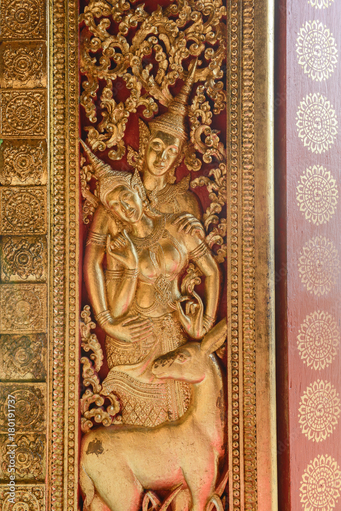 Art Craft of Devas on the door in Wat Xiengthong, Luang Prabang, Laos.