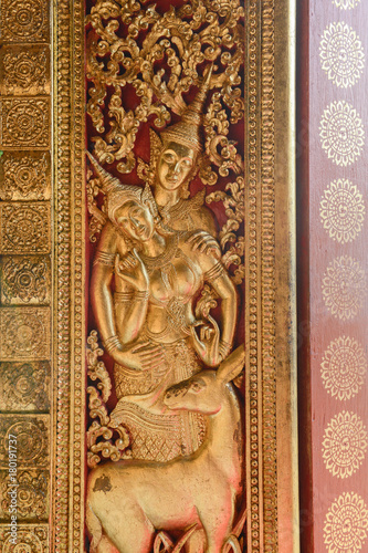 Art Craft of Devas on the door in Wat Xiengthong, Luang Prabang, Laos. © Jittrapon