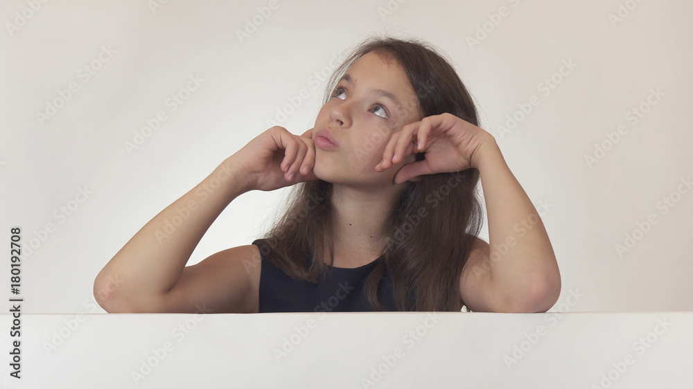 Beautiful girl teenager pondered over the poster with information on white background Beautiful girl teenager pondered over the poster with information on white background