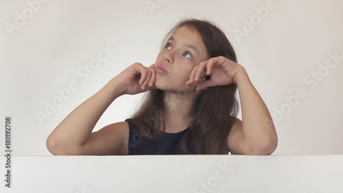 Beautiful girl teenager pondered over the poster with information on white background