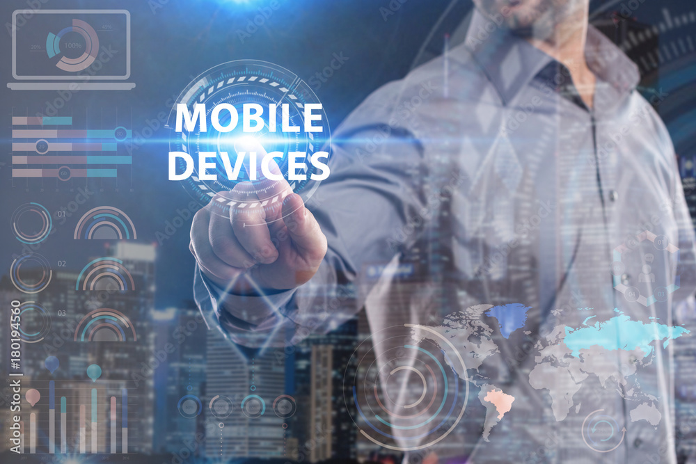 Business, Technology, Internet and network concept. Young businessman working on a virtual screen of the future and sees the inscription: Mobile devices Business, Technology, Internet and network concept. Young businessman working on a virtual screen of the future and sees the inscription: Mobile devices