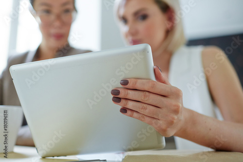 One of young women making presentation of online data to her colleague