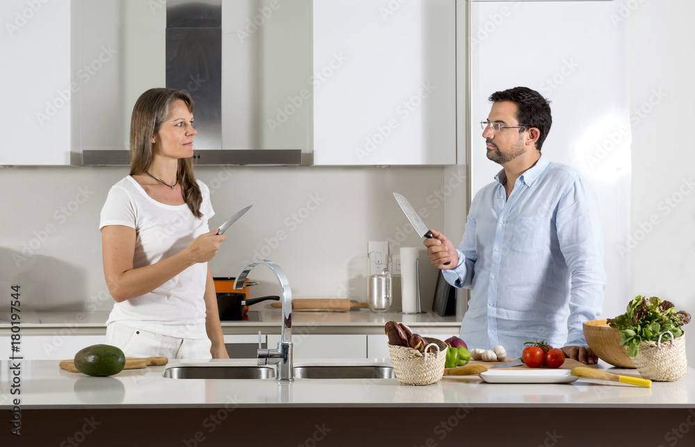 couple ready to fight over food preparation in their kitchen couple ready to fight over food preparation in their kitchen
