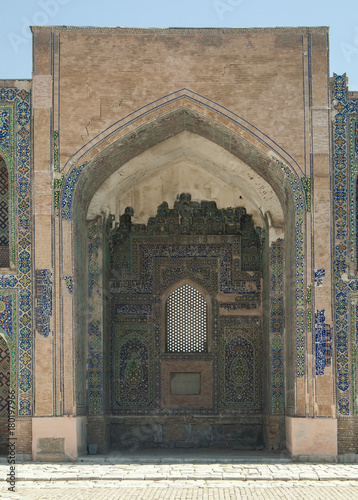 Arch and door with peeling traditional ancient Asian ornament. the details of the architecture of medieval Central Asia