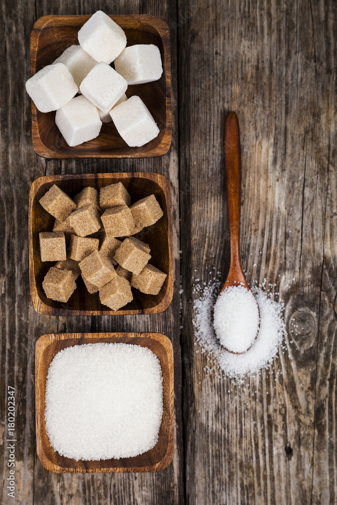 Three bowls with sugar and a wooden spoon