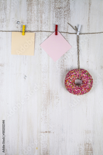 Pink donut and and two sheets of paper