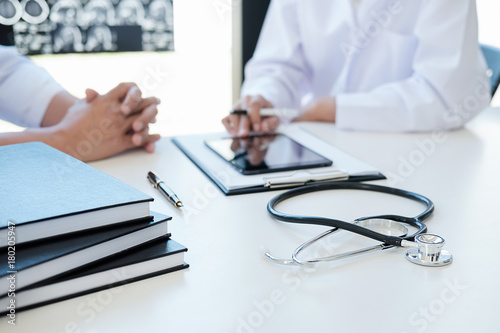 Obraz na plátne Patient listening intently to a male doctor explaining patient symptoms or askin
