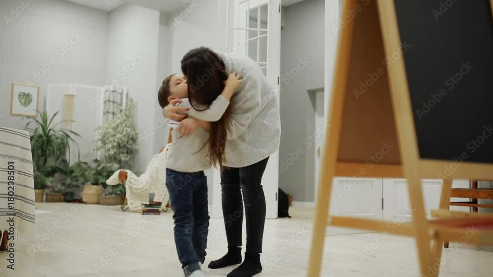 Little boy with mom in her living room house paint on the Board with markers a child's drawing. Leisure happy family. Pre-school education. Little boy with mom in her living room house paint on the Board with markers a child's drawing. Leisure happy family. Pre-school education.