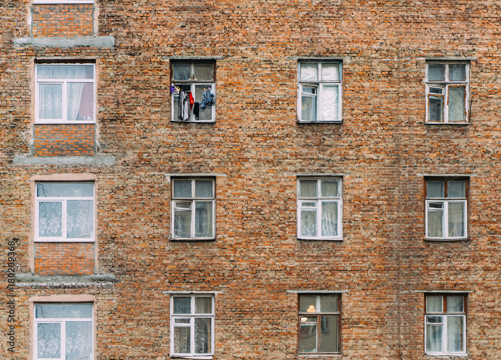 Fototapeta premium Brick wall with windows of an old apartment house seamless background