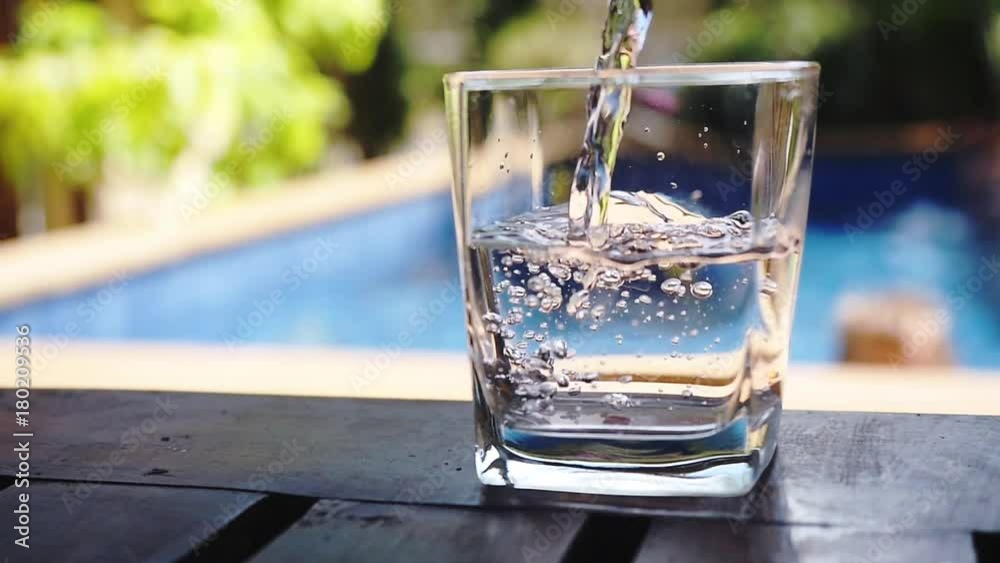 Pouring fresh water in a glass near swimming pool. Slow Motion. HD, 1920x1080 Pouring fresh water in a glass near swimming pool. Slow Motion. HD, 1920x1080