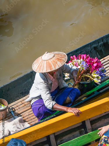 The local vendor on long wooden boat selling lotus flowers for Buddha worship to the tourists at Inle Lake, Shan State, Myanmar
