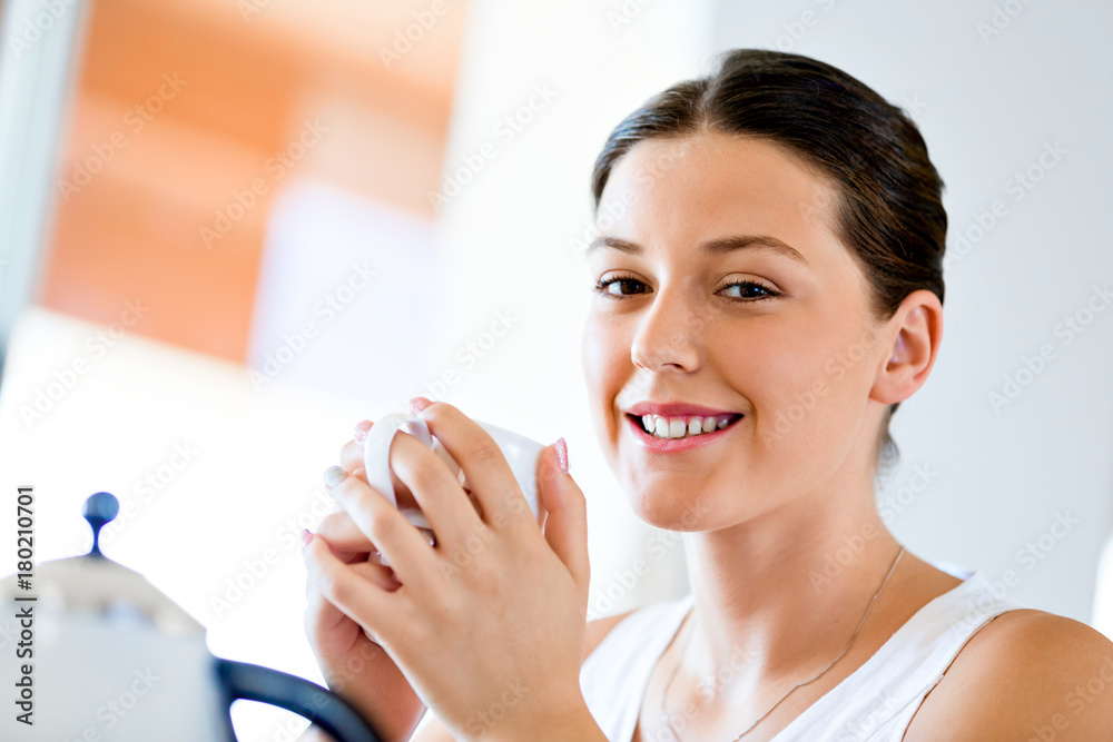 Happy young woman with cup of tea or coffee at home Happy young woman with cup of tea or coffee at home
